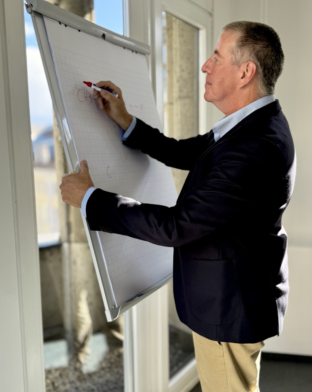 Sachverständiger erläutert eine chemische Strukturformel am Flipchart